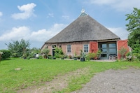 Bauernhaus am Lauwers mit Ruderboot